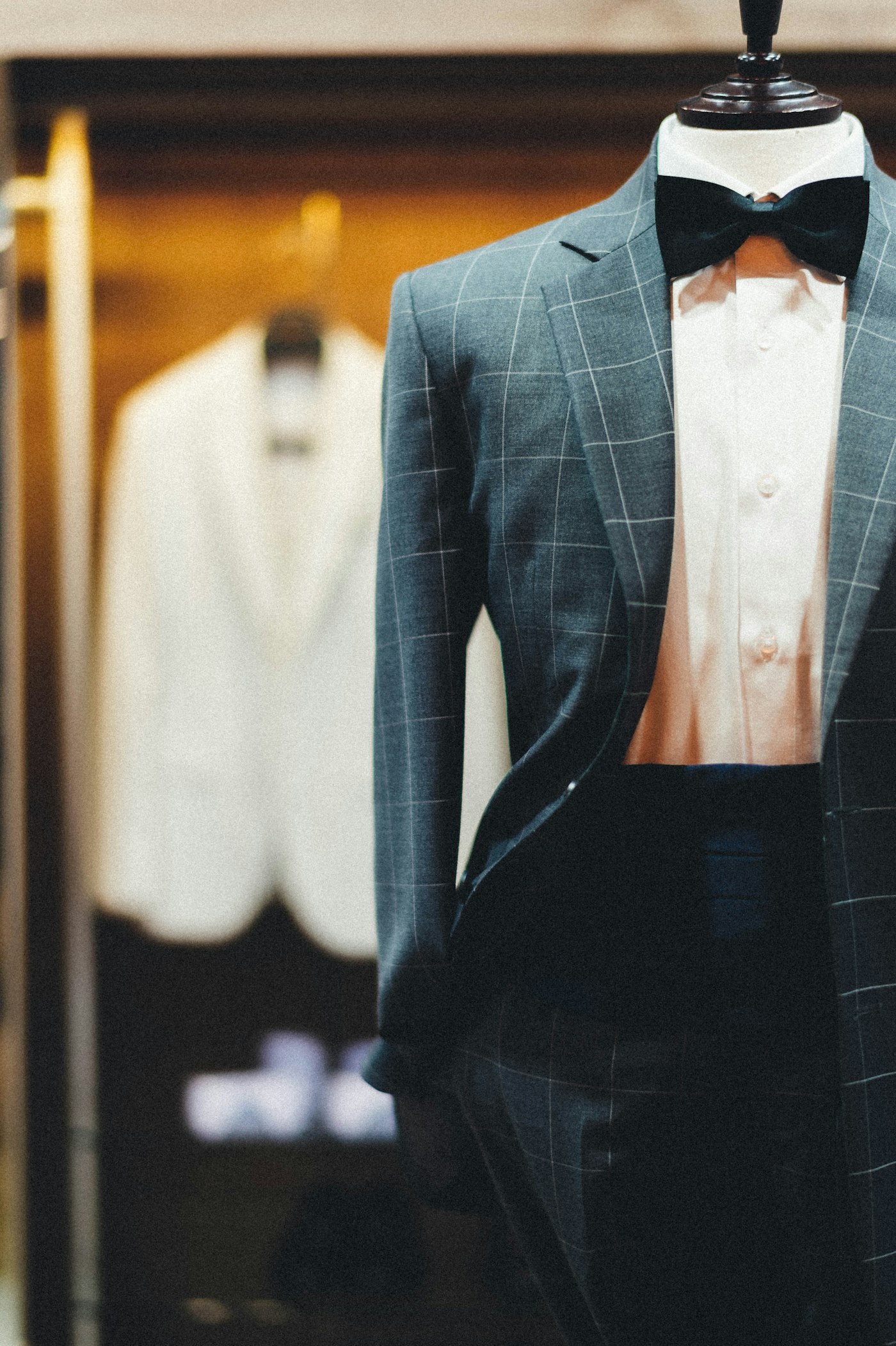 Windowpane dinner jacket with black velvet bow tie on a tailor's form