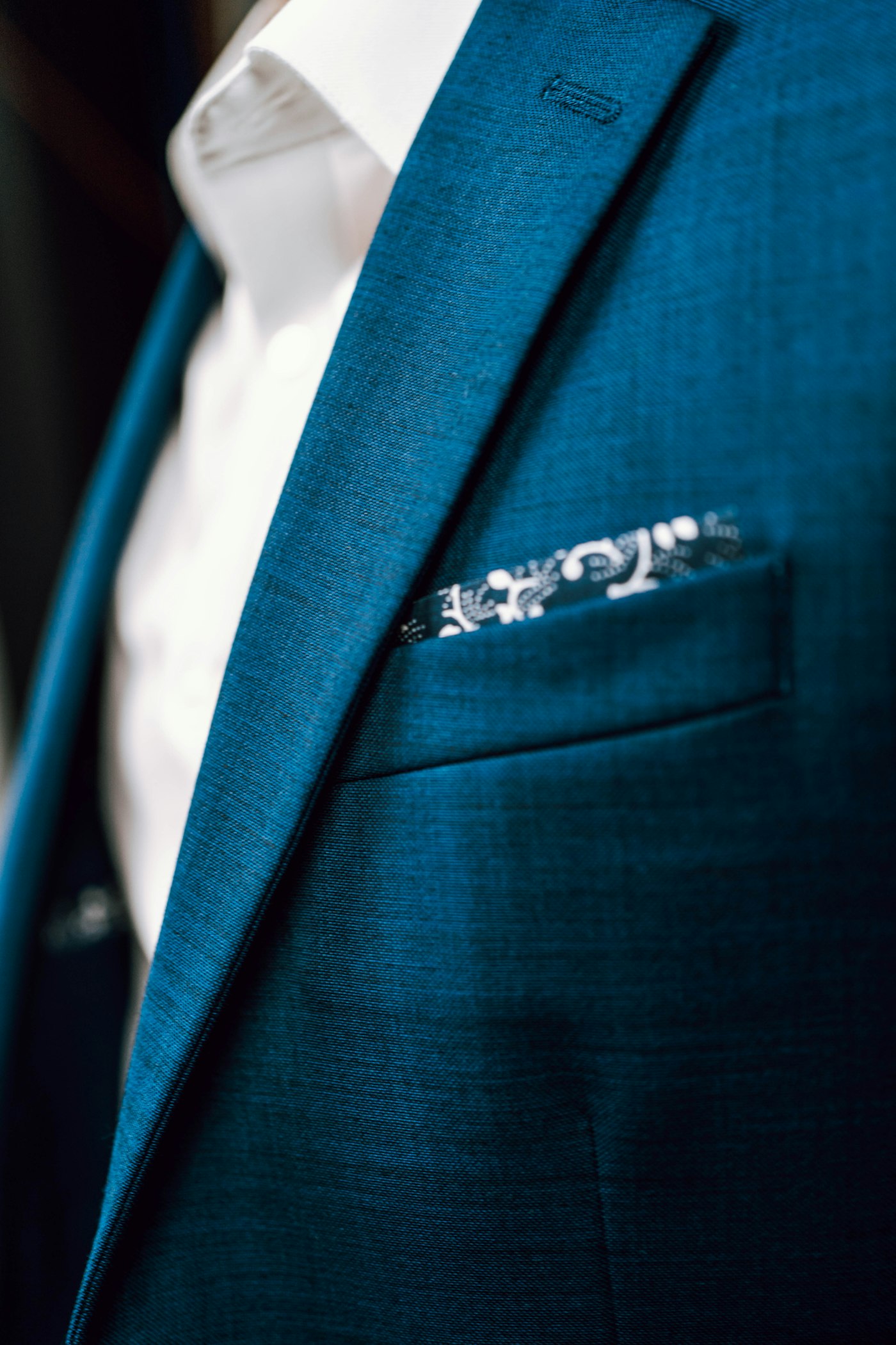 Peacock-blue jacket lapel with patterned pocket square